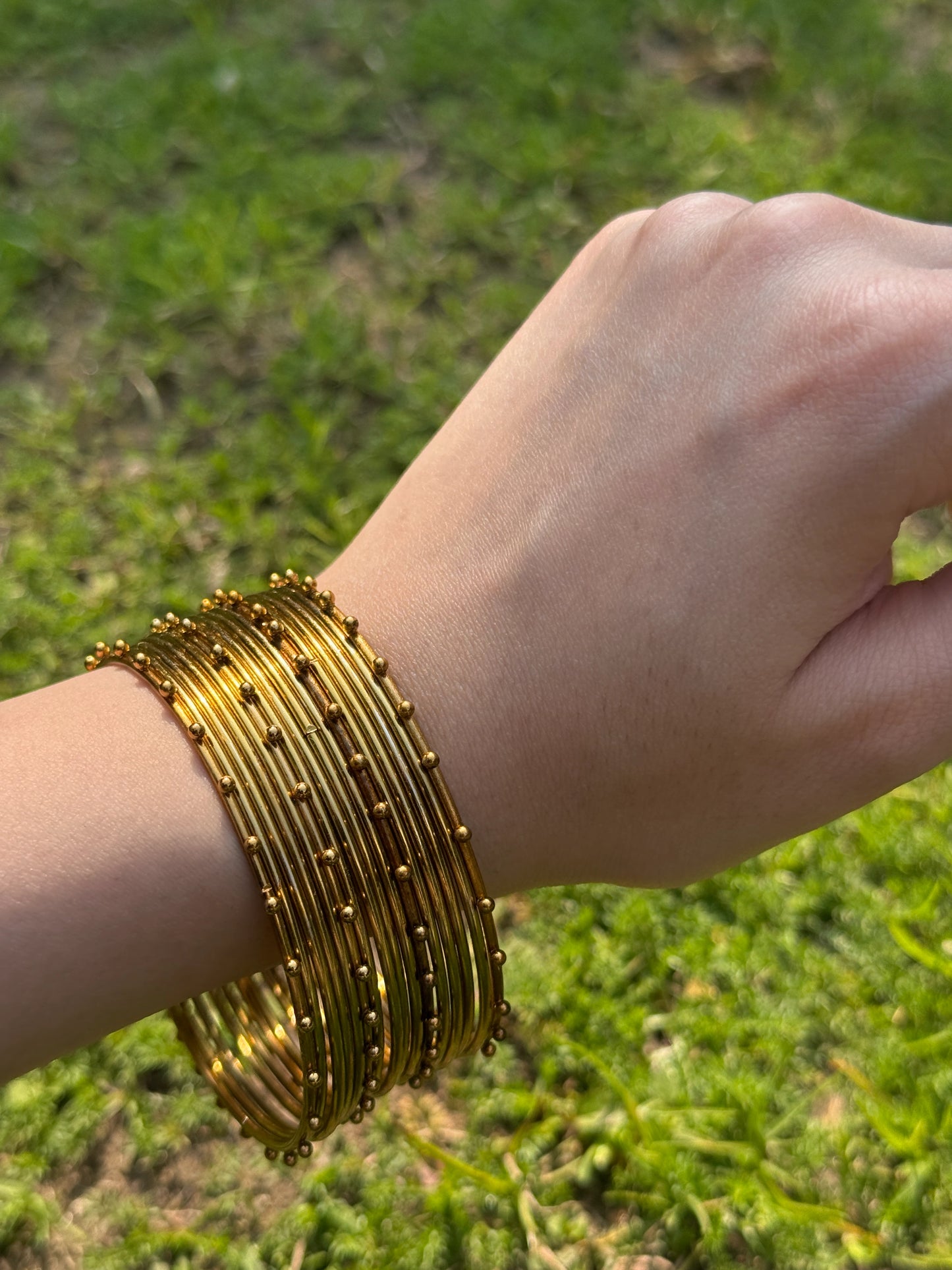 Close view of golden churiyan bangles with intricate traditional Pakistani craftsmanship