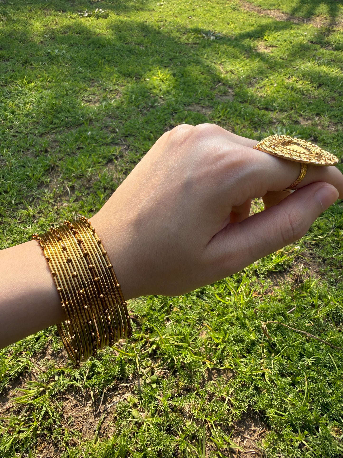 Model wearing golden churiyan bangles styled with Pakistani wedding and festive outfit
