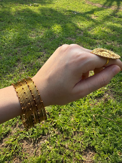 Model wearing golden churiyan bangles styled with Pakistani wedding and festive outfit
