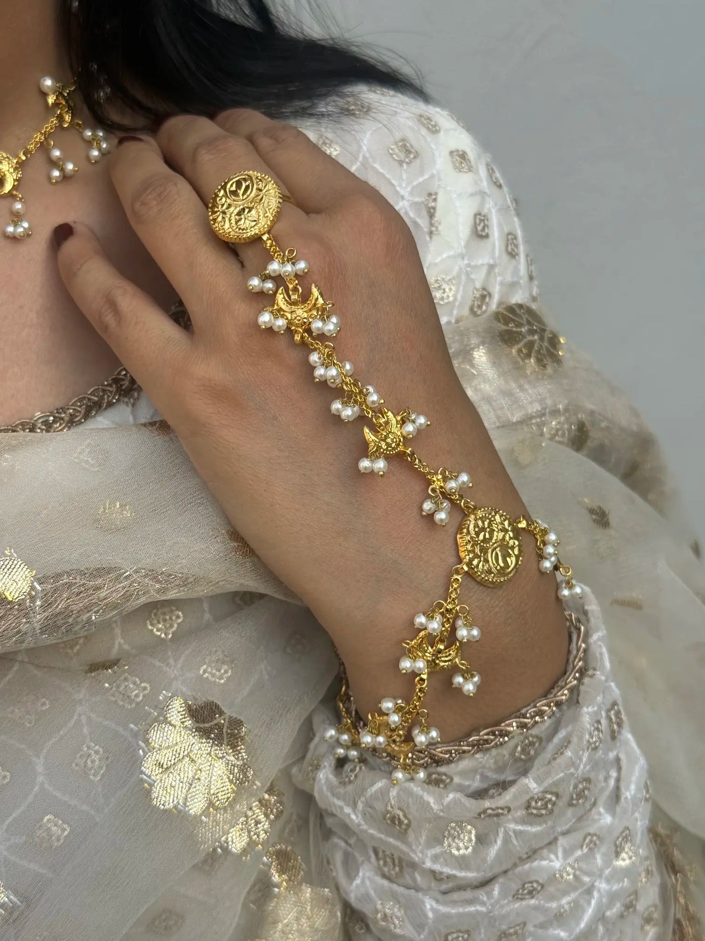 Close-up of Mahi Chand Angla hand chain jewelry showing intricate bridal detailing