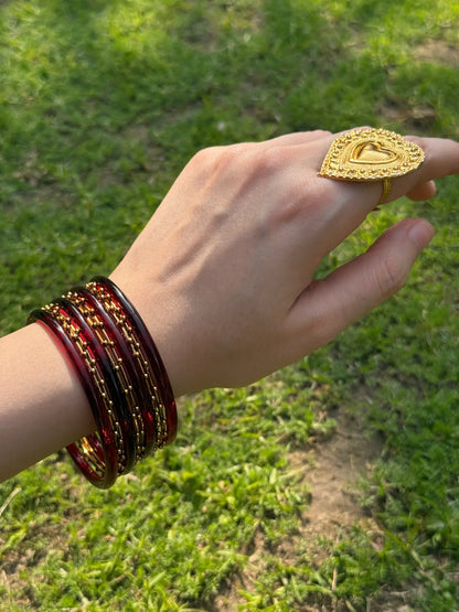 Model wearing maroon and golden bangle set styled with traditional festive wear
