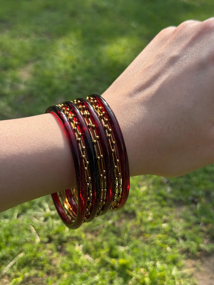 Stacked maroon and golden bangle set displayed from multiple angles