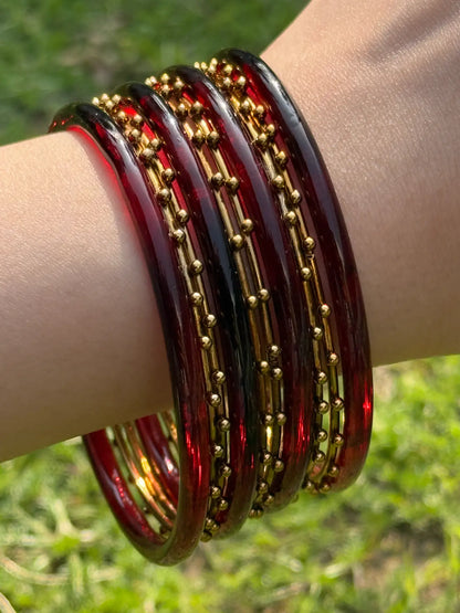 Close-up of maroon and golden bangles showing craftsmanship and ornate texture